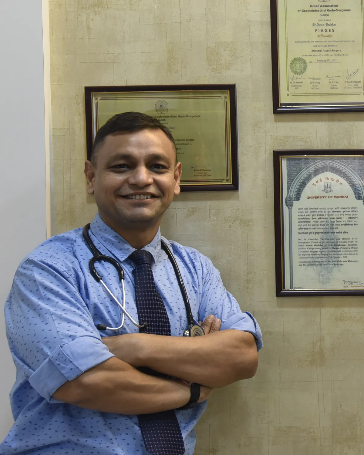 Dr Samir Deolekar at Asha Surgical Clinic, in front of his certificates